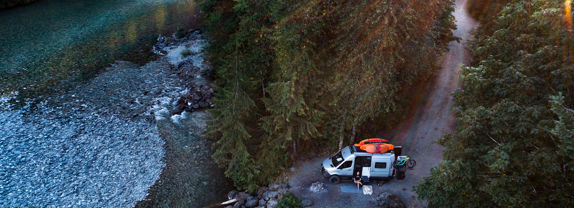 Drone photo of campervan parked next to a river
